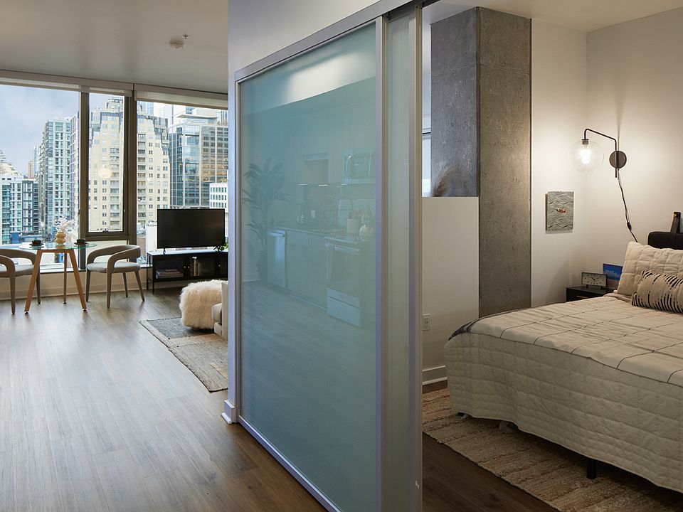 Spacious apartment bedroom with wood-style flooring.