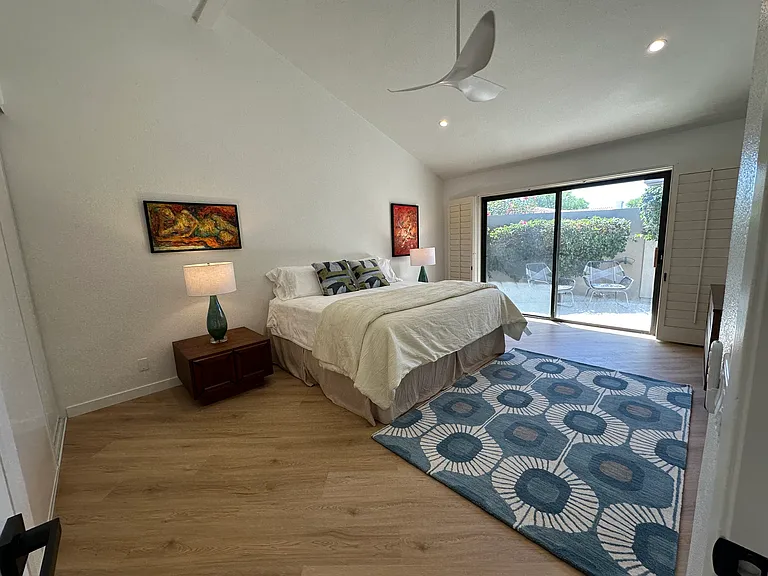 Primary suite with king bed and door to a patio