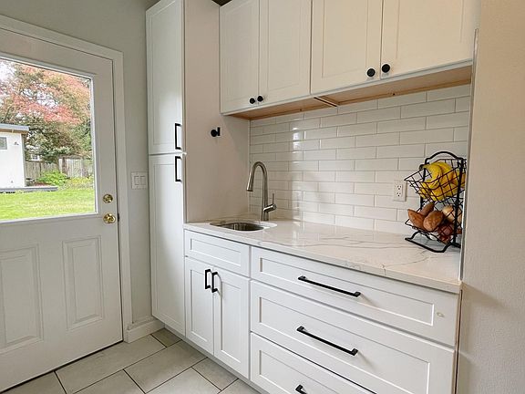Secondary kitchen area / pantry space with sink and storage space and access to backyard