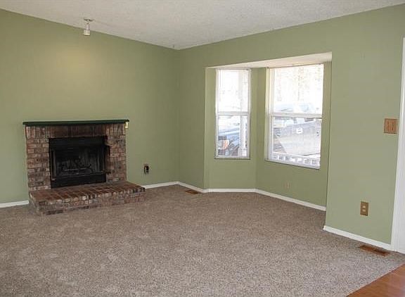 Living room with fireplace, bay window and vaulted ceiling