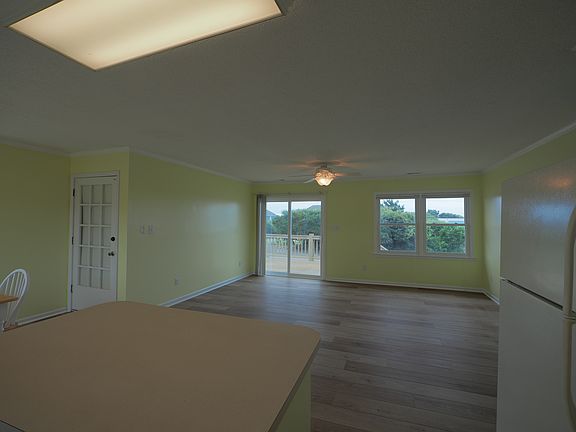 View of living room from kitchen. Door separating levels is on the left.