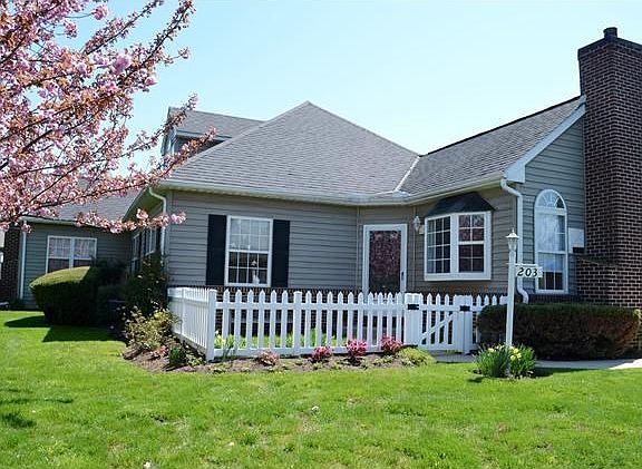 Charming entry w/ flower beds & picket fencing