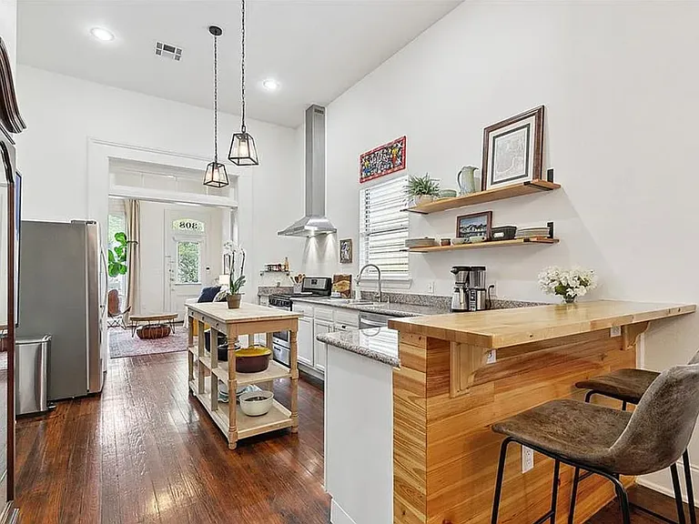 bar with stools facing the kitchen with plenty of room for a dining table behind