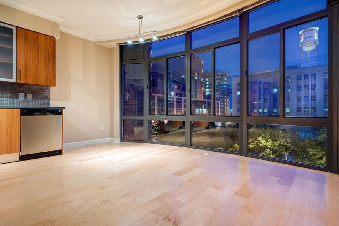 Kitchen with granite countertop, stainless steel appliances, designer backsplash, hard surface flooring and floor to ceiling windows