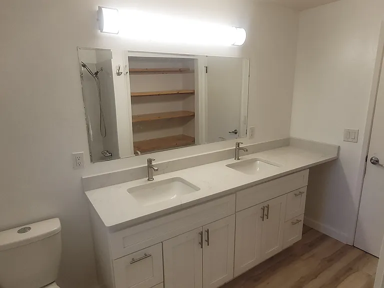 New dual sink vanity with quartz countertop and Moen faucets; outlets on either side of faucets