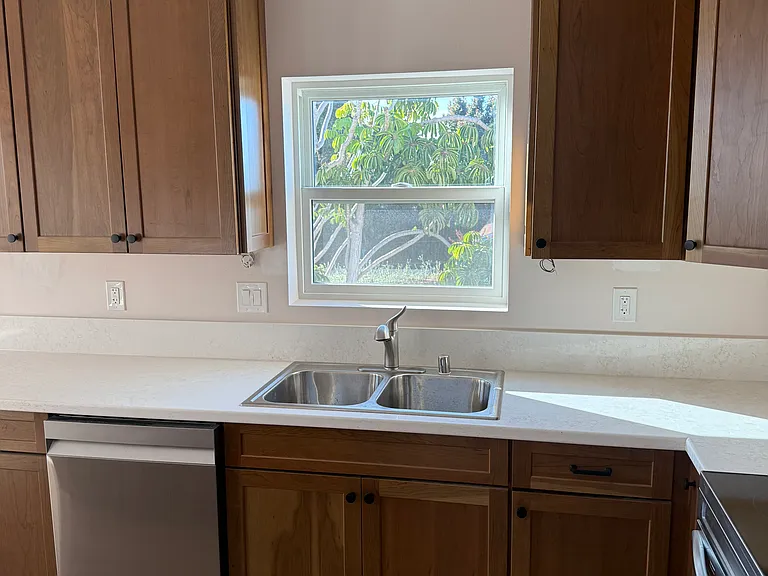 Kitchen with ample storage and window over sink with peekaboo ocean view