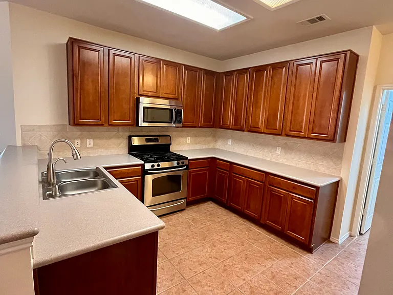 Spacious kitchen with plenty of cabinet storage room stainless steel appliances and well lit