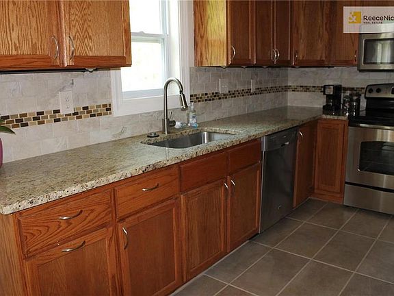 Updated kitchen features granite counters,mosaic backsplash, tile floor and stainless appliances.