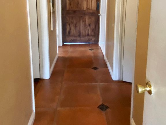 Hallway giving access to bedroom, laundry room, bathroom, and garage.