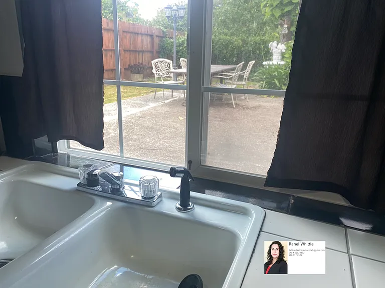 View out the kitchen sink onto fenced in yard