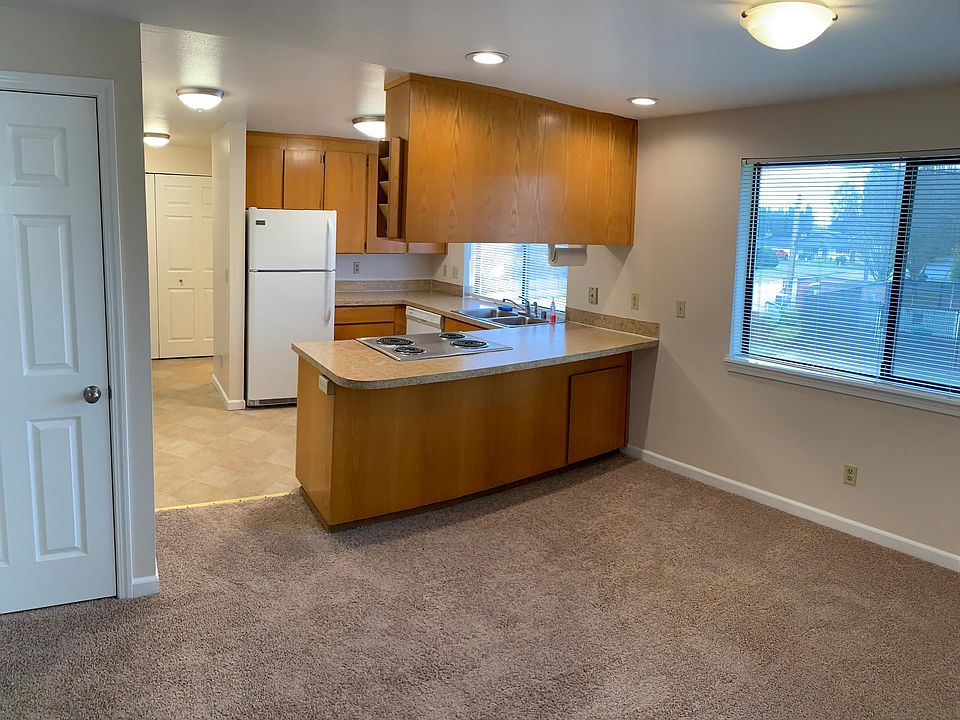 View of kitchen from dining area near front door. Coat closet on left.
