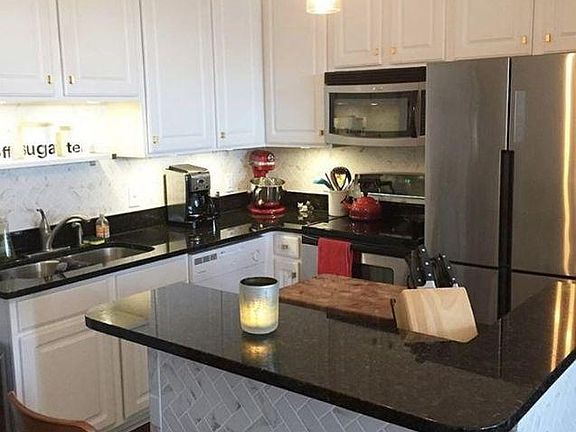 Kitchen with Marble backsplash and stainless steel appliances.