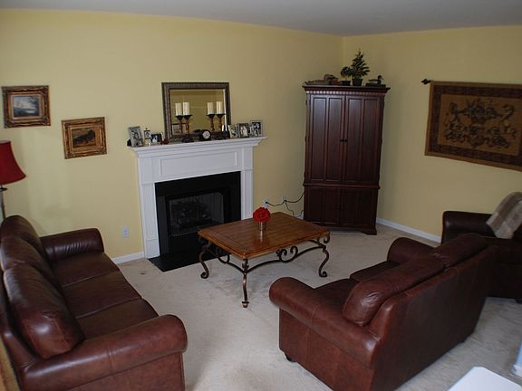 Cozy Den with fireplace that opens into kitchen