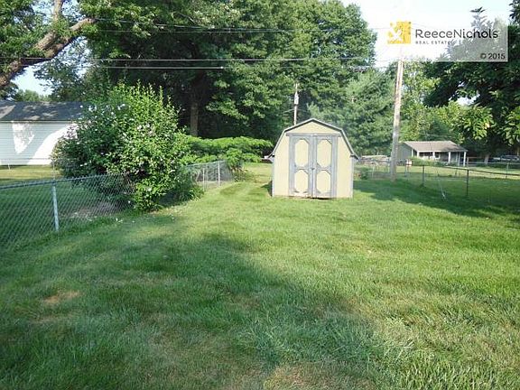 Property includes shed and extends south from fence.