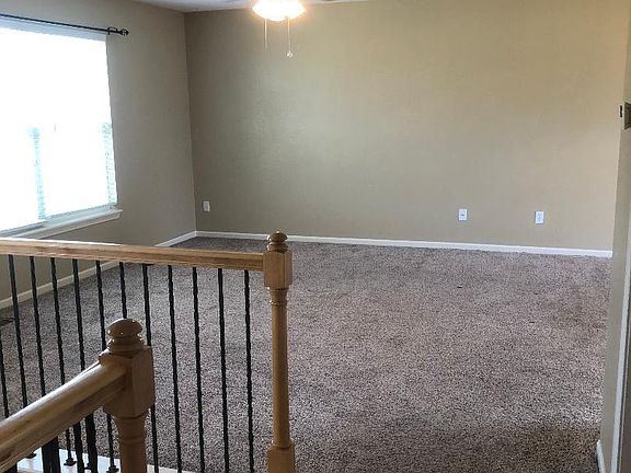 Upstairs living area with ceiling fan. Blinds through out home
