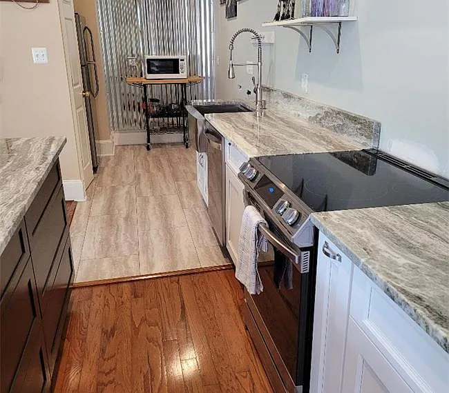 New open kitchen with everything needed to prepare meal. DW electric slide in range Refrigerator with ice maker Micro wave.