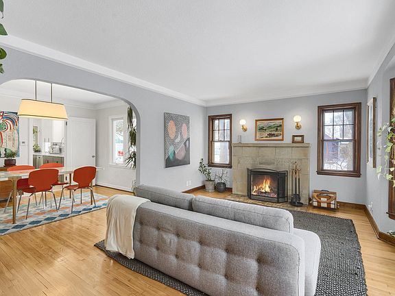 Spacious living room with refinished hardwood floors, bay window and wood-burning fireplace