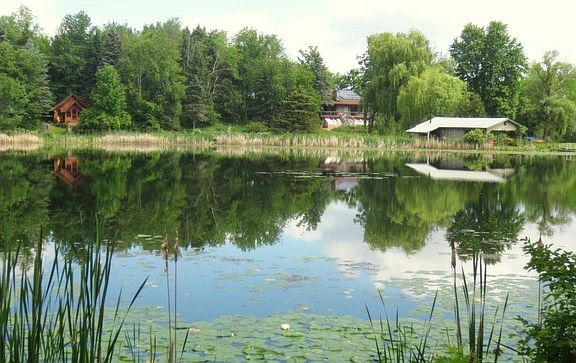 View of house, cottage and pavilion from across lake