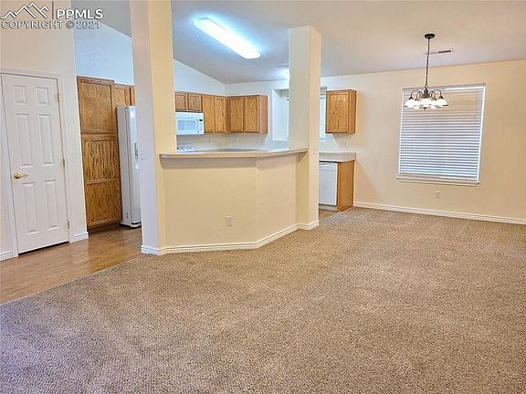 Bright open concept living room flows into dining area and kitchen.