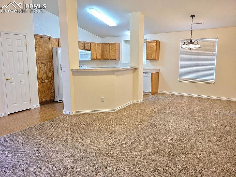 Bright open concept living room flows into dining area and kitchen.
