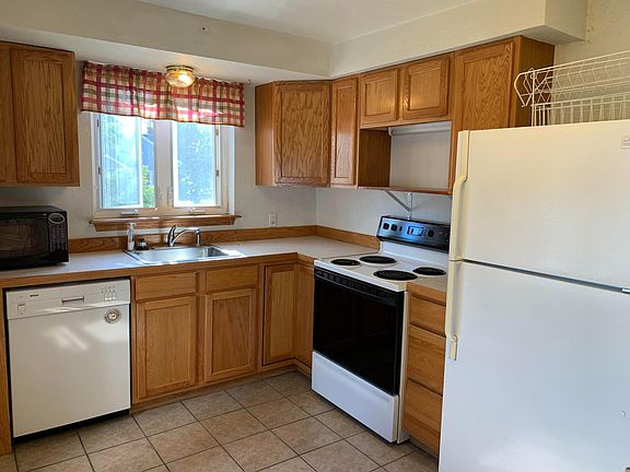 Kitchen. Oak cabinets. Laminate counters. Electric range, refrigerator, microwave, and dishwasher. New windows.