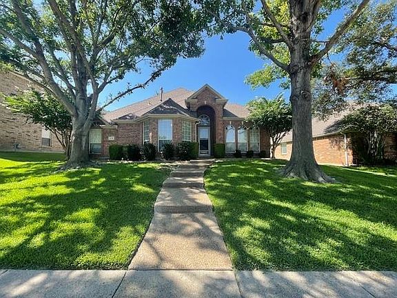 Ranch-style house with a front yard and brick siding