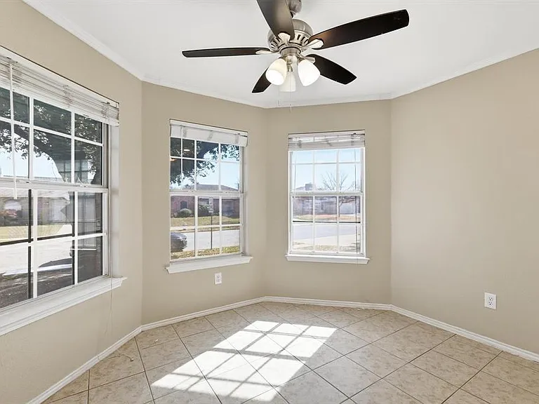 Unfurnished room with ceiling fan, ornamental molding, and light tile patterned flooring
