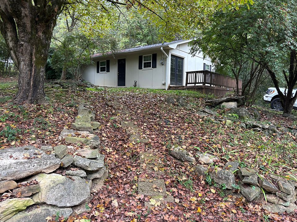 the wide front exterior with trees and the white house