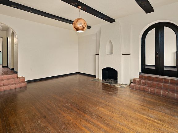 Sunken living room view, double glass doors leading to the second bedroom. To the left is the hallway with one of two entries into the apartment. Bathroom and master bedroom at the end of the hallway.