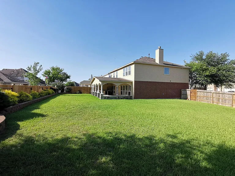 Beautiful, spacious backyard with flower bed.