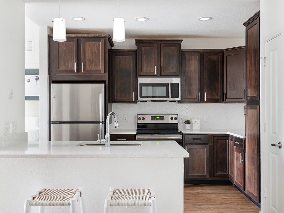 Gourmet kitchens feature quartz countertops, stainless-steel appliances, wood cabinetry, and modern designer details