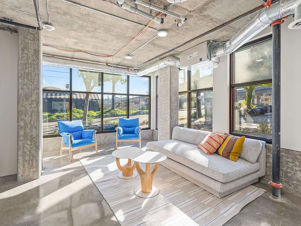 Experience the comfort and elegance of our spacious living room, featuring a cozy couch, stylish tables, and ample natural light.