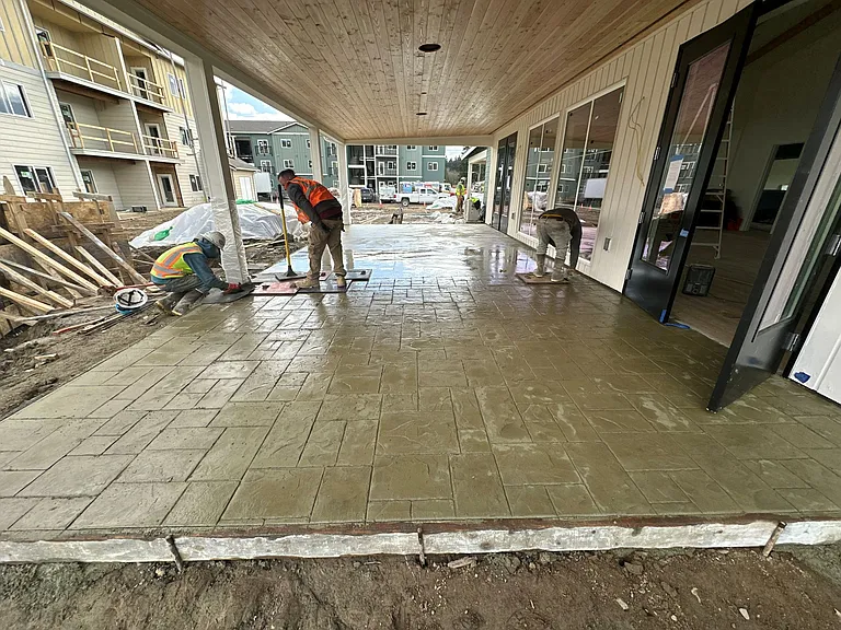 Crews installing the stamped concrete covered walkway at The Elowen in Lacey, Washington. This outdoor space will soon provide residents with a weather-protected area to enjoy year-round.