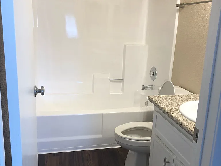 Full bathroom with granite counter top and brushed nickel fixtures at Grande Vista Apartments.