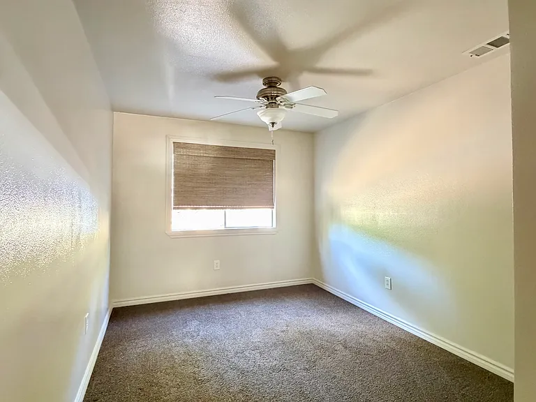 Bedroom #2 with mirrored closet, ceiling fan, and blackout shades