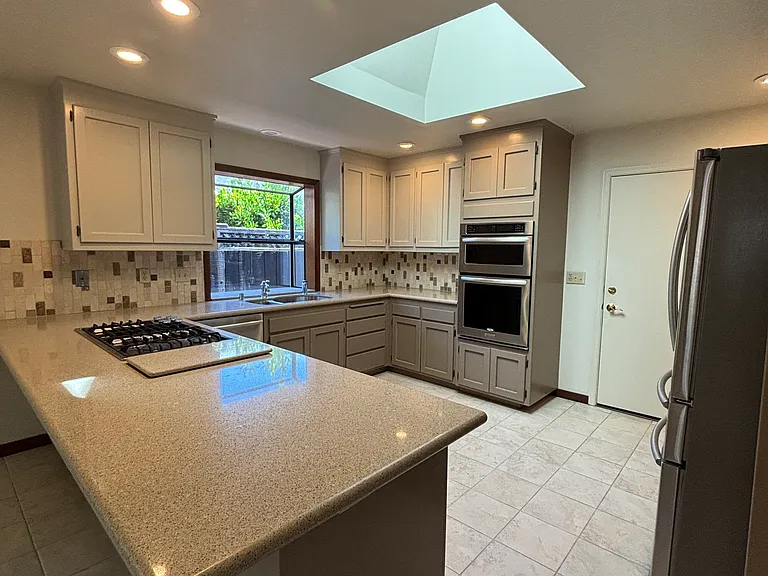 Open Kitchen with new high-end S/S appliances and freshly painted sold wood cabinetry