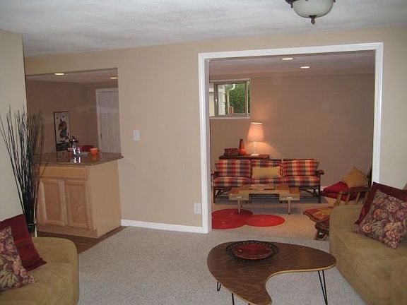living area heading into kitchen on the left and family room ahead