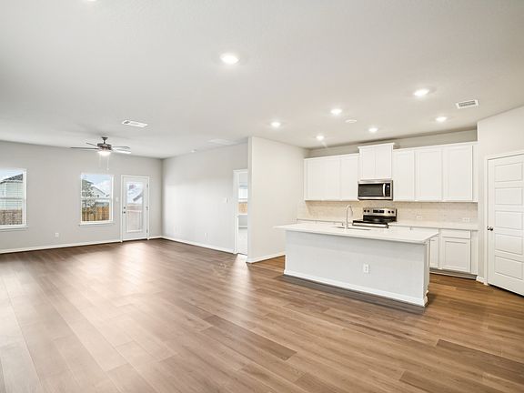 Dining room and kitchen of the Reynolds floorplan at a Meritage Homes community.