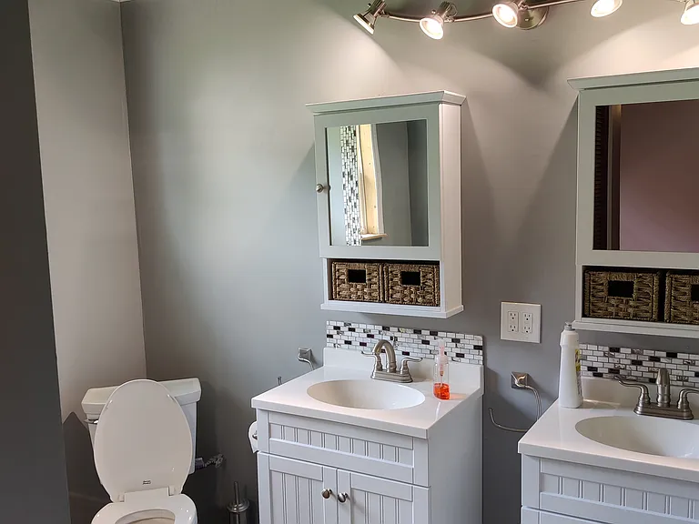 Master bathroom with custom cieling, tile floor, track lighting, dual vanities with custom backsplash, medicine cabinets and custom mirror with matching backsplash wto the sinks and shower.