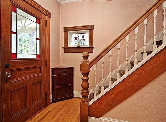 The entry foyer features stained glass window and original wood trim.  Hardwood flooring throughout the main level.