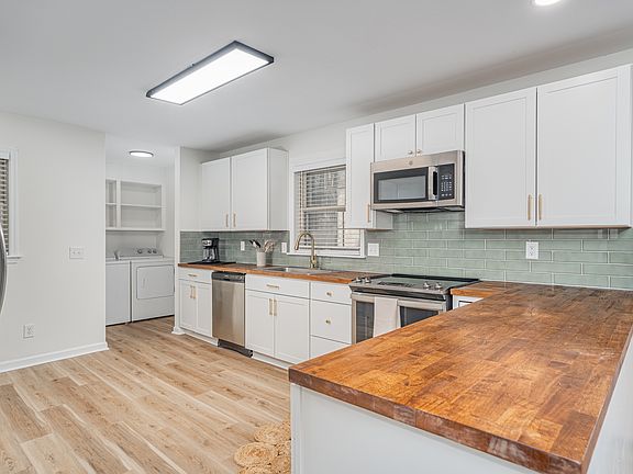 Kitchen with butcher block countertop, all new cabinets, flooring and appliances