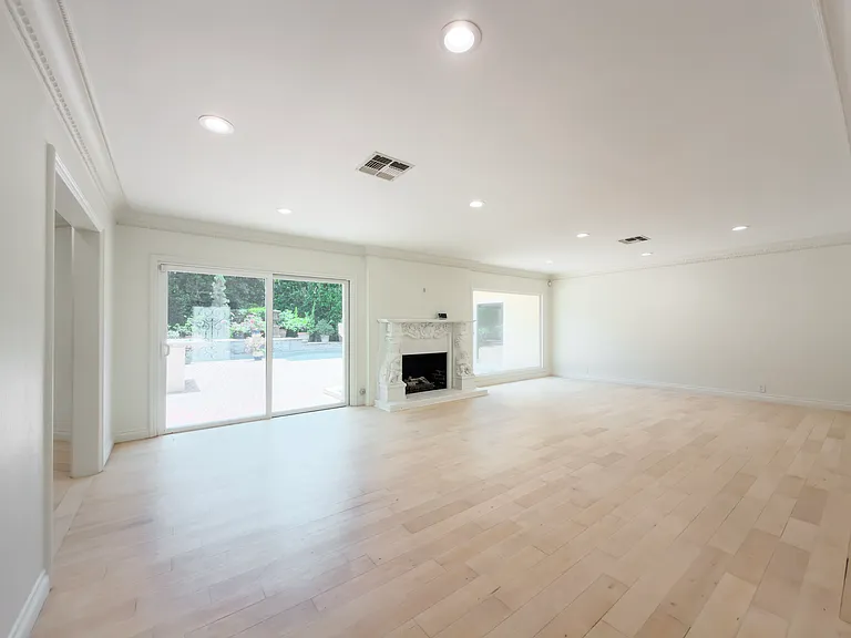 Wall-to-wall sliding glass doors frame serene backyard views in this Beverly Hills luxury rental living space at 1094 Garden Lane, ideal for a 90210 lease.
