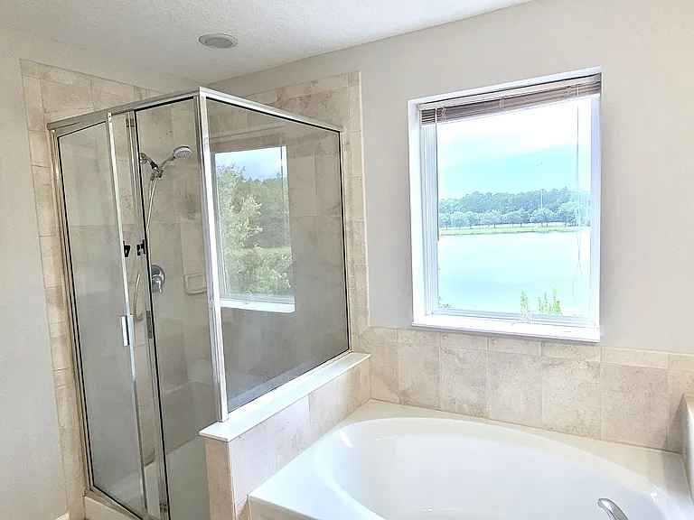 Master Bathroom with hot tub and walk in shower with Lake view