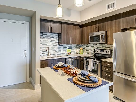 Kitchen and kitchen island within open concept apartment in Boca Raton.