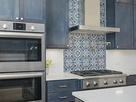 Designer backsplash with pot filler & double ovens.
