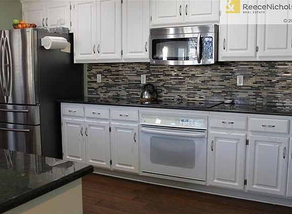 Designer perfection!  Gorgeous granite, mosaic tile backsplash, wood floor.