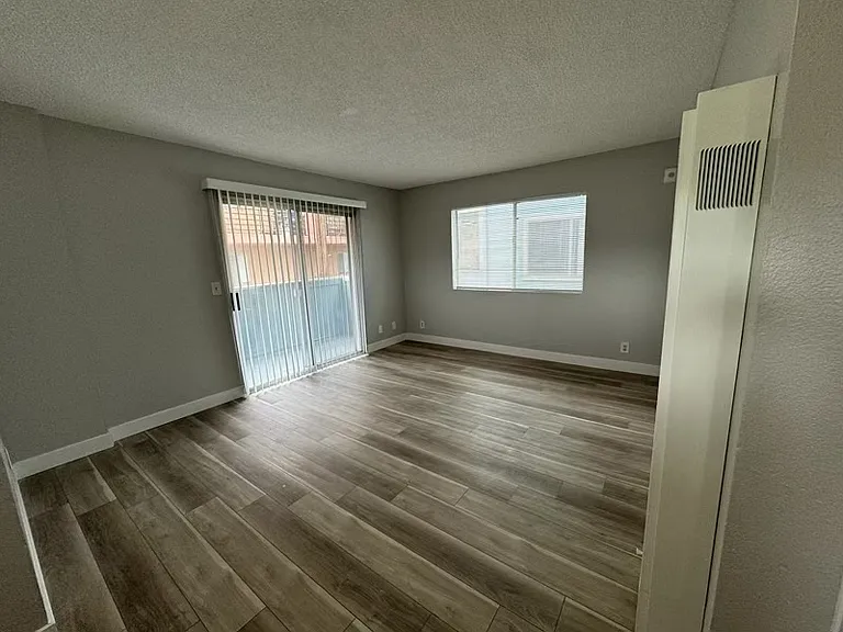 Spacious living room with bright, natural light and balcony.