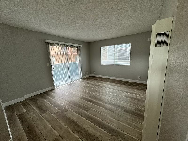 Spacious living room with bright, natural light and balcony.