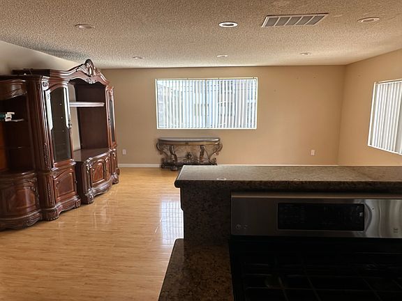 View from the kitchen into the living room area with large windows'