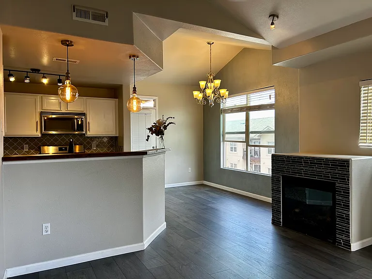View from living room of the gas fireplace and kitchen area and breakfast nook.